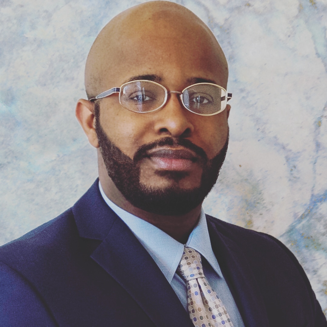 Professional portrait of an attorney in a suit and glasses.